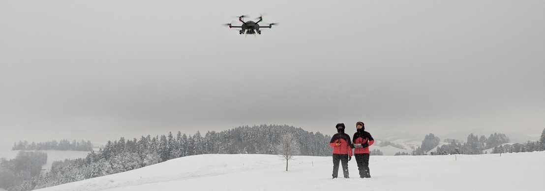 Vergrösserte Ansicht: Ein schwebendes UAV mit zwei Pilotinnen die sicher stellen, dass alles ordnungsgemäss funktioniert während eines Experiments.